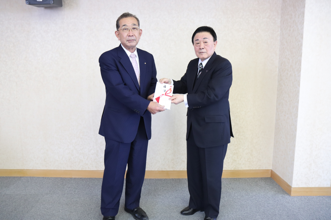 目録贈呈式 竹内代表理事(右)から市川理事長(左)へ